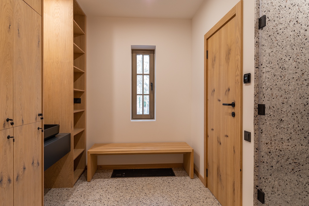 SPA changing room at Chalet Alpino Resort featuring bespoke oak lockers, vanity basin, open shelving, and integrated wellness joinery.