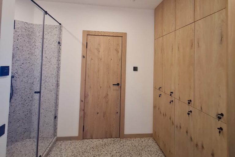 Spa changing room at Chalet Alpino Resort featuring timber lockers and terrazzo flooring