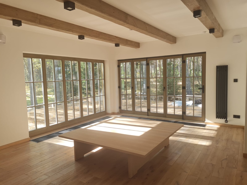 Main hall interior at the SPA in Chalet Alpino Resort featuring central wellness table and panoramic glazing