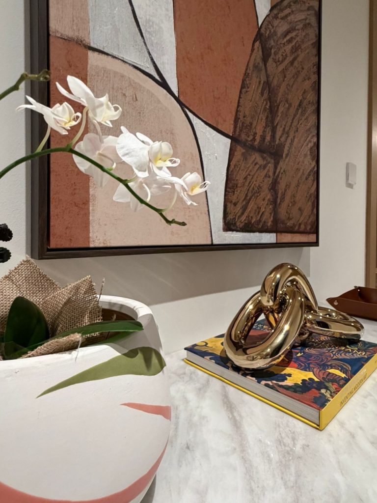 Luxury villa entrance hall console design in Dubai by Claire Dominics Buro featuring marble top and curated decorative styling