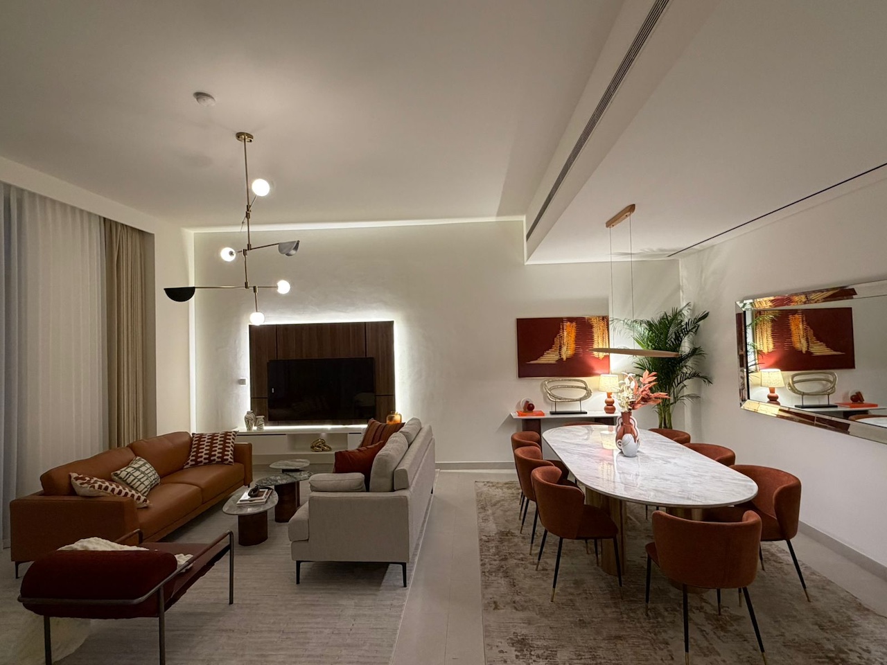 Luxury villa living and dining room interior design in Dubai by Claire Dominics Buro featuring bespoke furnishing and contemporary lighting